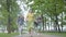 Mature elegant woman running in the park with her two granddaughters holding hands. Grandmother spending time with