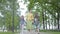 Mature elegant woman walking in the park with her two granddaughters. Happy family holding hands. Grandmother spending