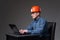 Mature engineer in hardhat at his laptop