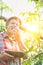 Mature farmer eating newly harvest tomatoes in greenhouse with yellow lens flare in background