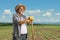 Mature farmer with a straw hat leaning on a shovel on a field