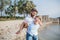 Mature father carrying small daughter on a holiday by the lake, walking.