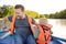 Mature father and little son boating on a river or pond at sunny summer day. Quality family time together on nature