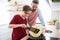 Mature father with small son indoors in kitchen, making pancakes.