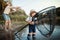 A mature father with a small toddler son outdoors fishing by a lake.