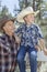 Mature father and son wearing cowboy hats looking away in park