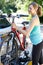 Mature Female Cyclist Taking Mountain Bike From Rack On Car