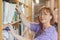 Mature female librarian taking a book off a shelf