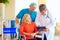 Mature female patient on wheelchair listens to doctor prescription medication