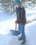Mature female shoveling snow.
