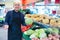 Mature friendly smiling positive seller offering seasonal vegetables