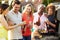 Mature Friends Enjoying Outdoor Summer Barbeque In Garden