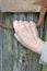 Mature grandmother holds his right hand behind a rusty metal bra