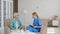 Mature grey haired female patient with medical mask at appointment with lady doctor sitting in armchairs in room