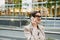 Mature grey woman talking on cellphone while standing on city street