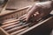 Mature hand reaching for a tool inside a wooden box