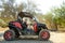 Mature handsome man driving buggy car on sandy hills of Cyprus or Greek in summer. Off road extreme trip