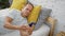 Mature, handsome middle age man comfortably relaxed, lost in his smartphone, texting intensely while lying in bed, blanket and