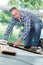 Mature handyman installing wooden floor in building