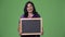 Mature happy beautiful Indian woman smiling while showing blackboard