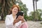 Mature hispanic woman reading an ebook on an electronic reader sitting in a park