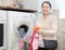 Mature housewife loading the washing machine