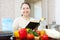 Mature housewife reads cookbook for recipe