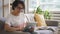 Mature housewife is using tablet, sitting on sofa in modern home interior.