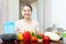 Mature housewife with vegetables at kitchen