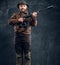 Mature hunter with rifle and binoculars. Studio photo against dark wall background