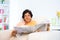 Mature Indian woman reading news paper