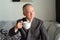 Mature Japanese businessman thinking while drinking coffee at home