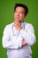 Mature Japanese man doctor against green background