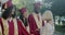 Mature lady college professor hugging graduate students congratulating with diploma on campus