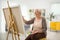 Mature lady painting on a canvas