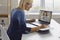 Mature lady taking notes while watching online lecture or having video call with coach