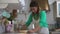 Mature Latin woman kneading flour dough with rolling pin in old vintage kitchen