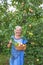 Mature laughing woman in the garden with apples