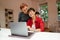 Mature lesbian couple smiling and hugging while using laptop