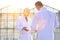 Mature male biochemists discussing while standing against clear blue sky