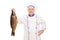 Mature male chef holding an uncooked fish