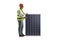 Mature male engineer with a vest and hardhat standing next to a photovoltaic panel