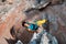 Mature Male Extreme Climber hanging on unusual shaped Rock