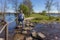 Mature male hiker standing on the stepping stones of Brug Molenplas, smiling and looking at camera