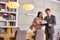 Mature male realtor and female buyer reading document while sitting at table in apartment