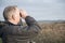 Mature man bird watching, holding a pair of binoculars