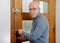 Mature man with blue pullover close the door