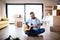 Mature man with boxes moving in new house, playing guitar.