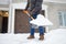 A mature man clean path near house from snow during strong blizzard. Person shoveling snow out of the driveway. Huge snowdrifts.