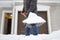 A mature man clean path near house from snow during strong blizzard. Person shoveling snow out of the driveway. Huge snowdrifts.